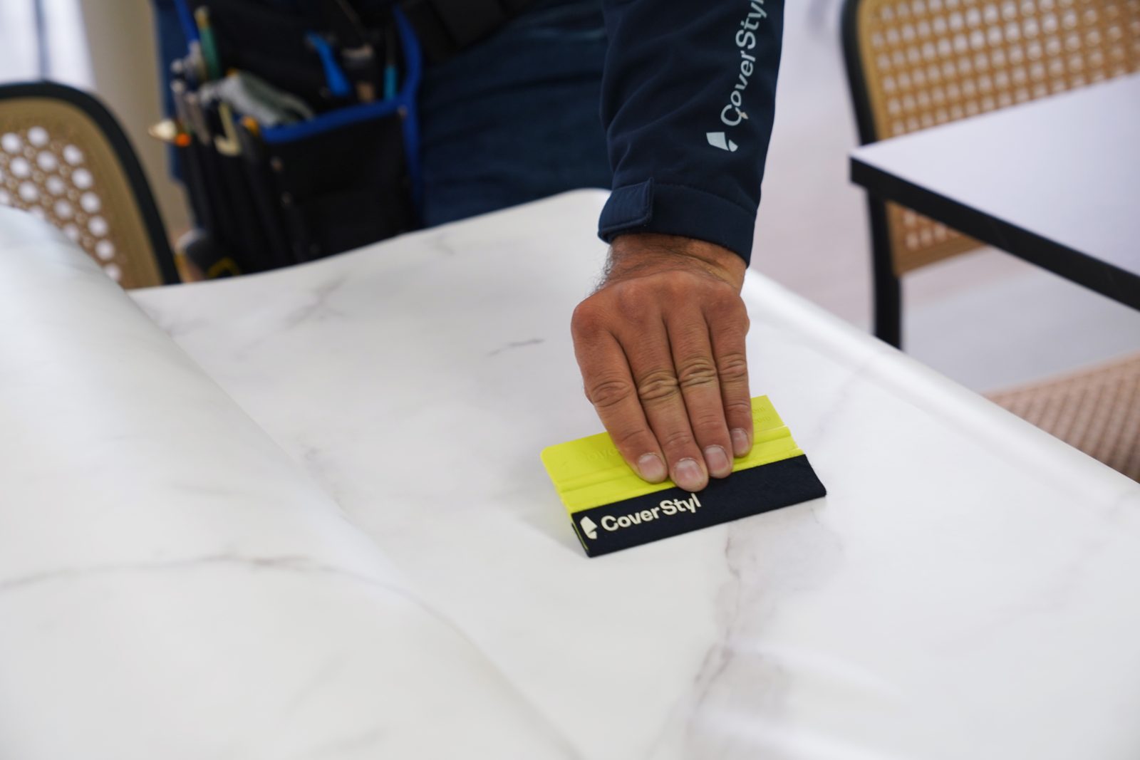 Espátula asentando vinil de mármol sobre una mesa